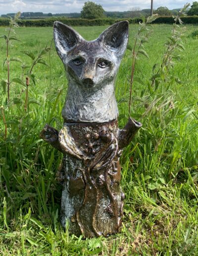 Sculpture en céramique représentant un arbre-totem à tête de renarde et à parure de lierre.