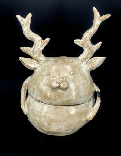 Sculpture en forme de boîte ronde en deux parties, représentant un cerf féminin aux bois, à la surface blanche et à l’intérieur noir mat.